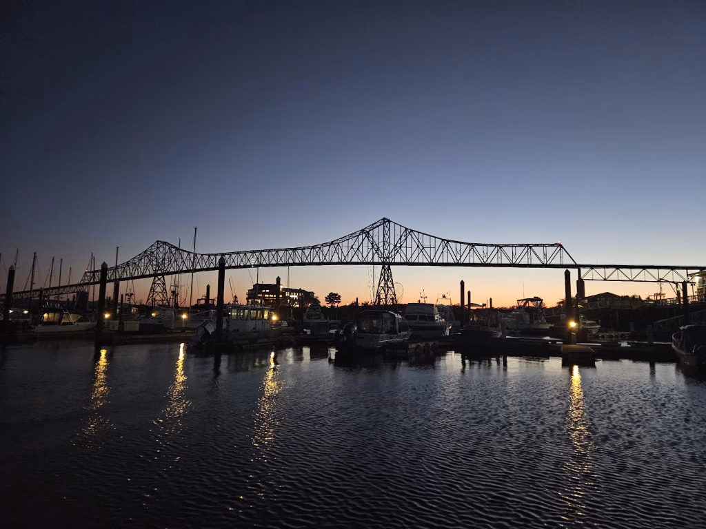 The Cannery Pier Hotel framed by the Megler bridge at sunrise as seen from the West Basin Marina in Astoria Oregon.