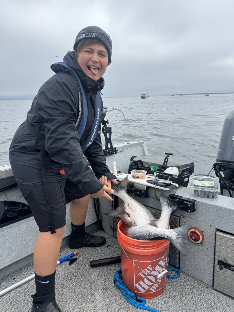 Levi showing off a bucket of freshly caught salmon As part of his birthday Astoria Salmon Fishing Charter during Buoy 10