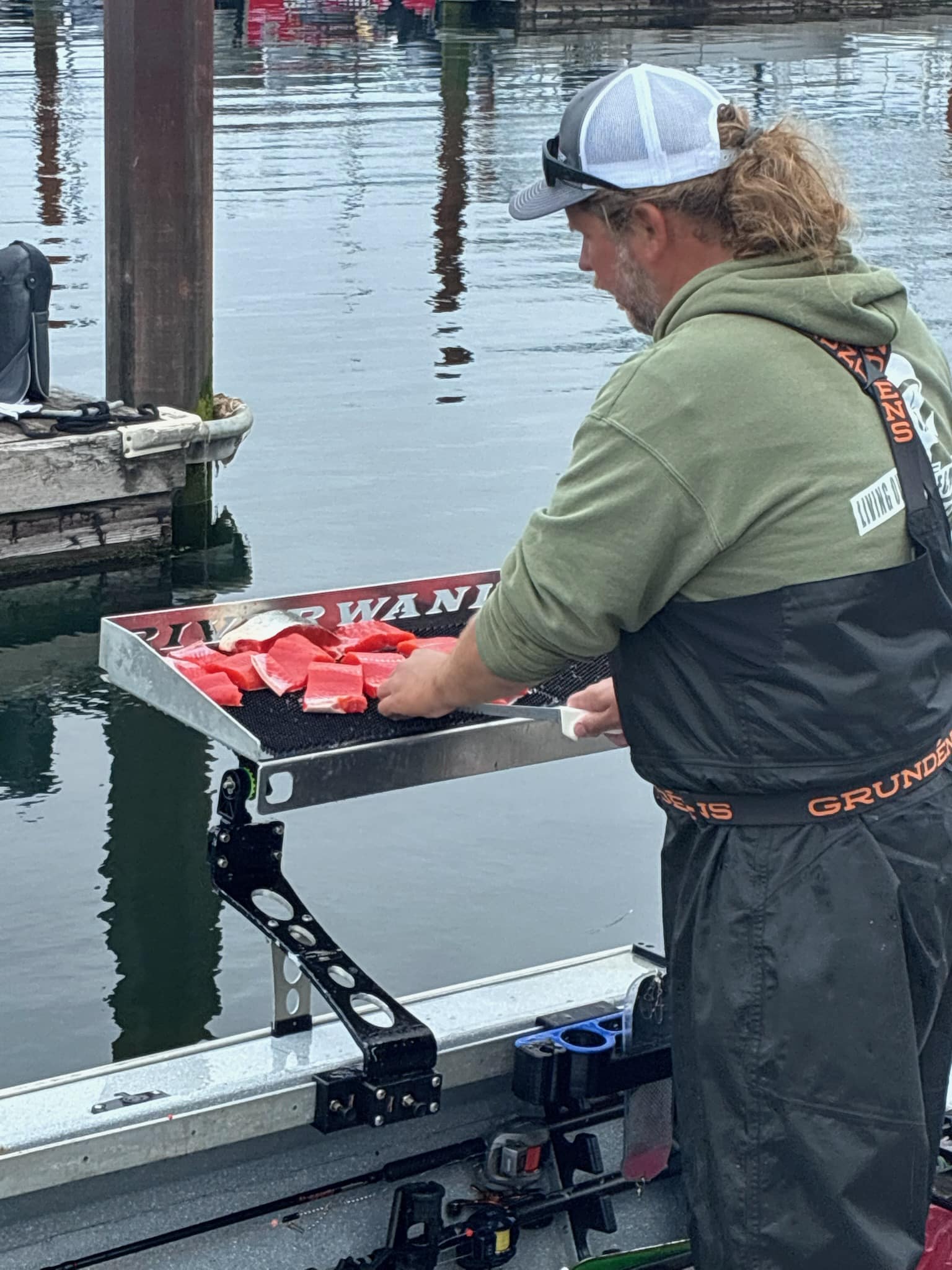 Astoria Fishing Guide Jerad Sorber filleting salmon for his clients at the West Basin Marina in Astoria Oregon after a successful Astoria Salmon Fishing Trip